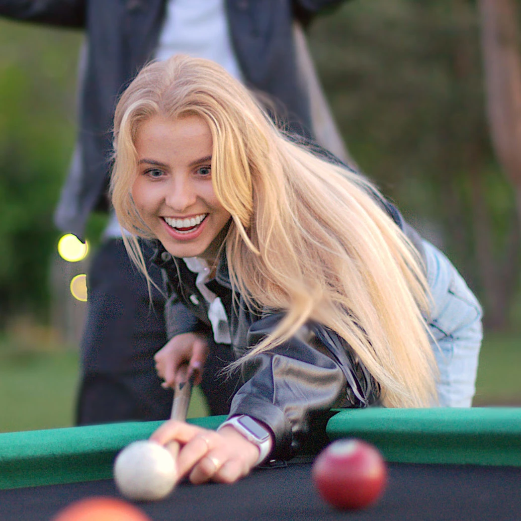blonde girl plays poolbil in park